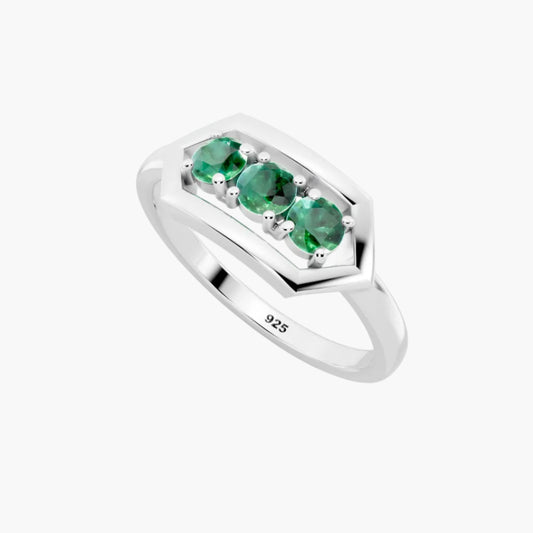 Silver ring with three green emerald stones on a white background