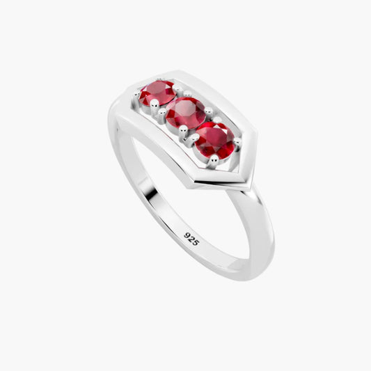 Silver ring with three red gemstones on a white background