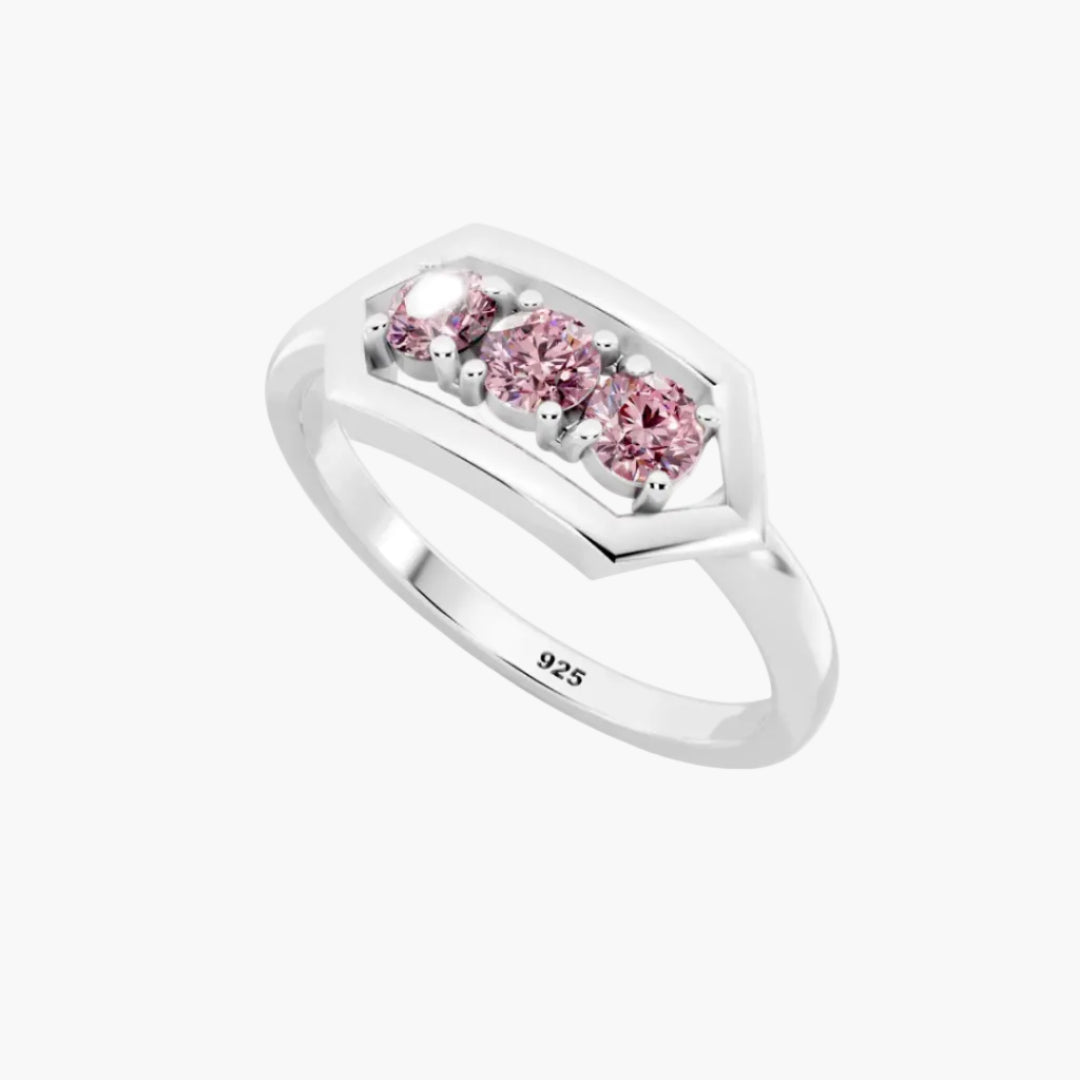 Silver ring with pink gemstones on a white background