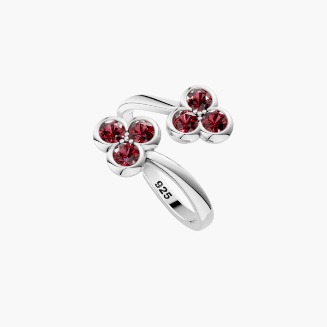 Silver ring with red gemstones on a white background