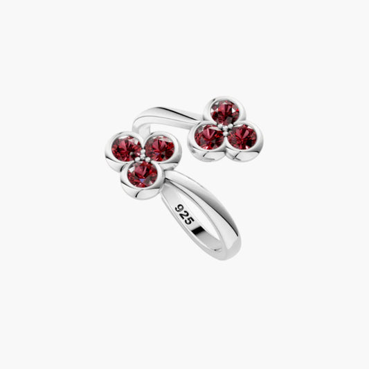 Silver ring with red gemstones on a white background